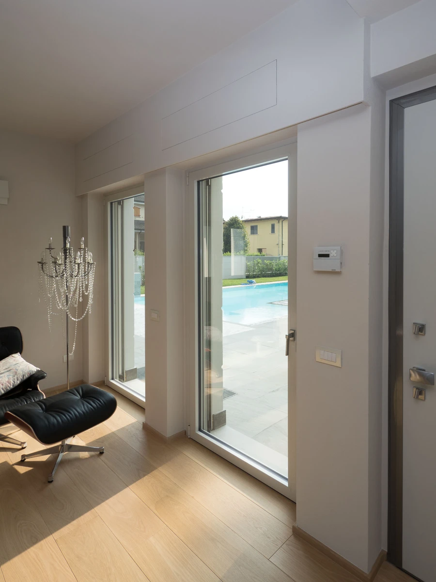 Grande porta finestra in alluminio bianco per sala in una abitazione moderna a piacenza