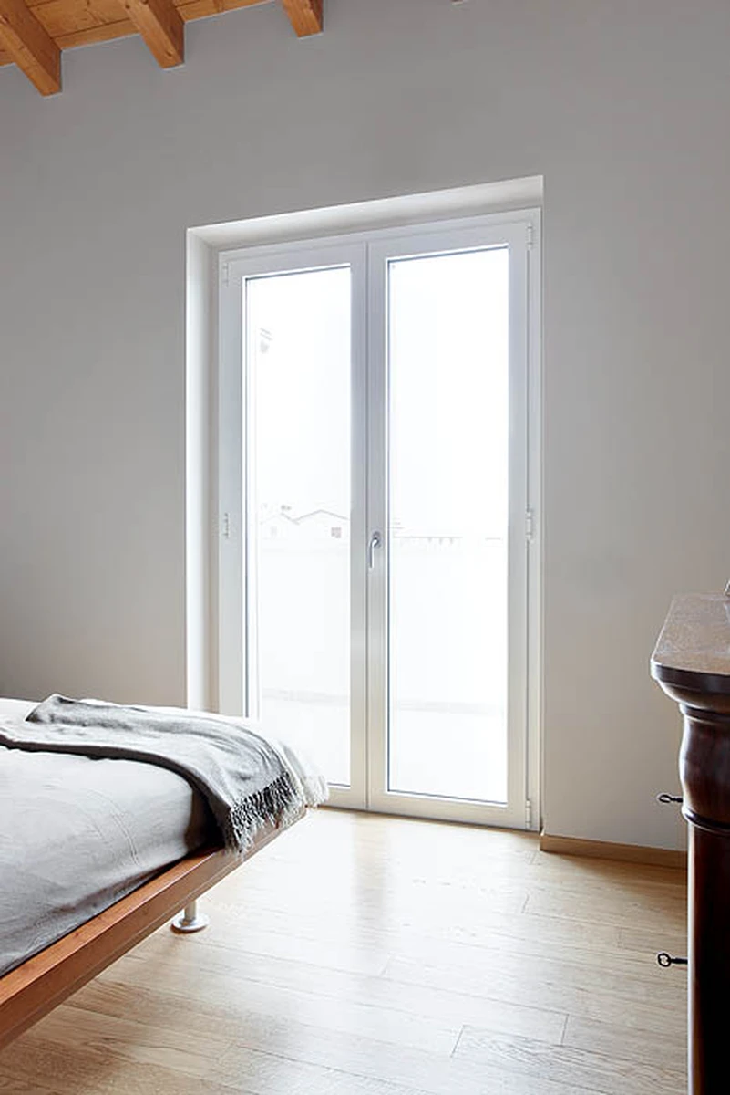 Porta finestra in alluminio bianco con maniglia zincata adatta per dare luce alla camera da letto