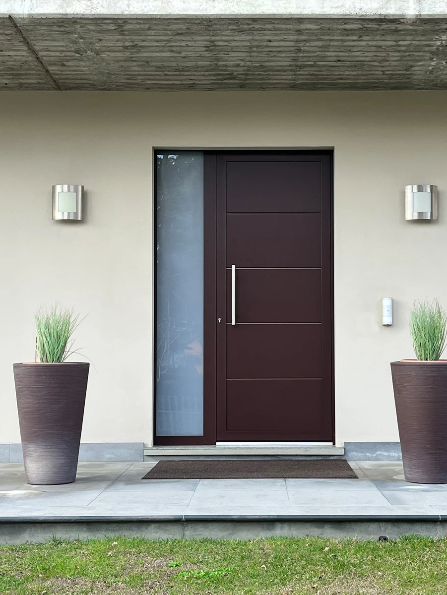 Porta di ingresso in alluminio marrone e profili color metallo con sezione in vetro opaco elegante e sicura per la tua casa