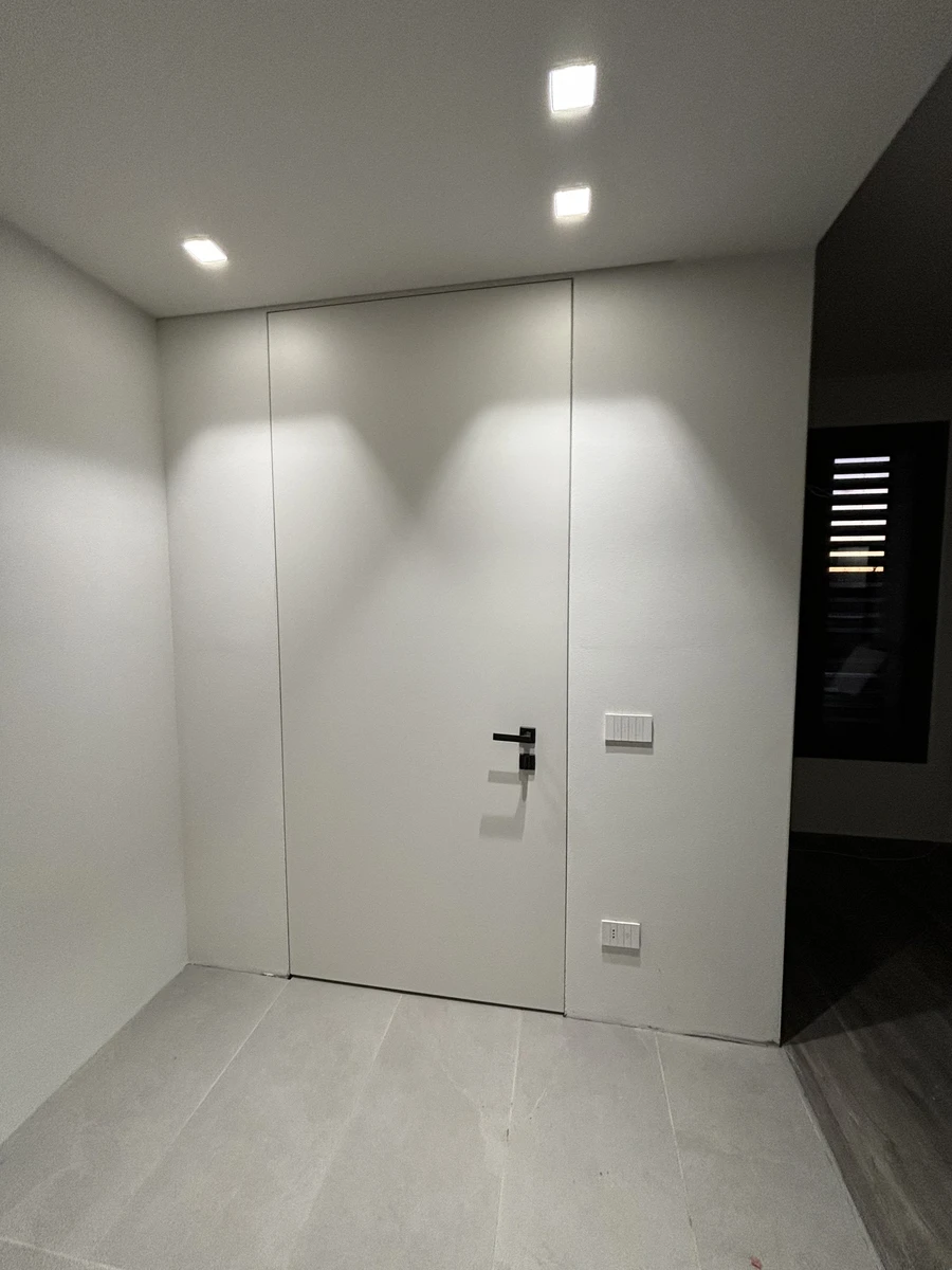 Porta blindata di ingresso color bianco con maniglia nera squadrata dal design moderno e raffinato