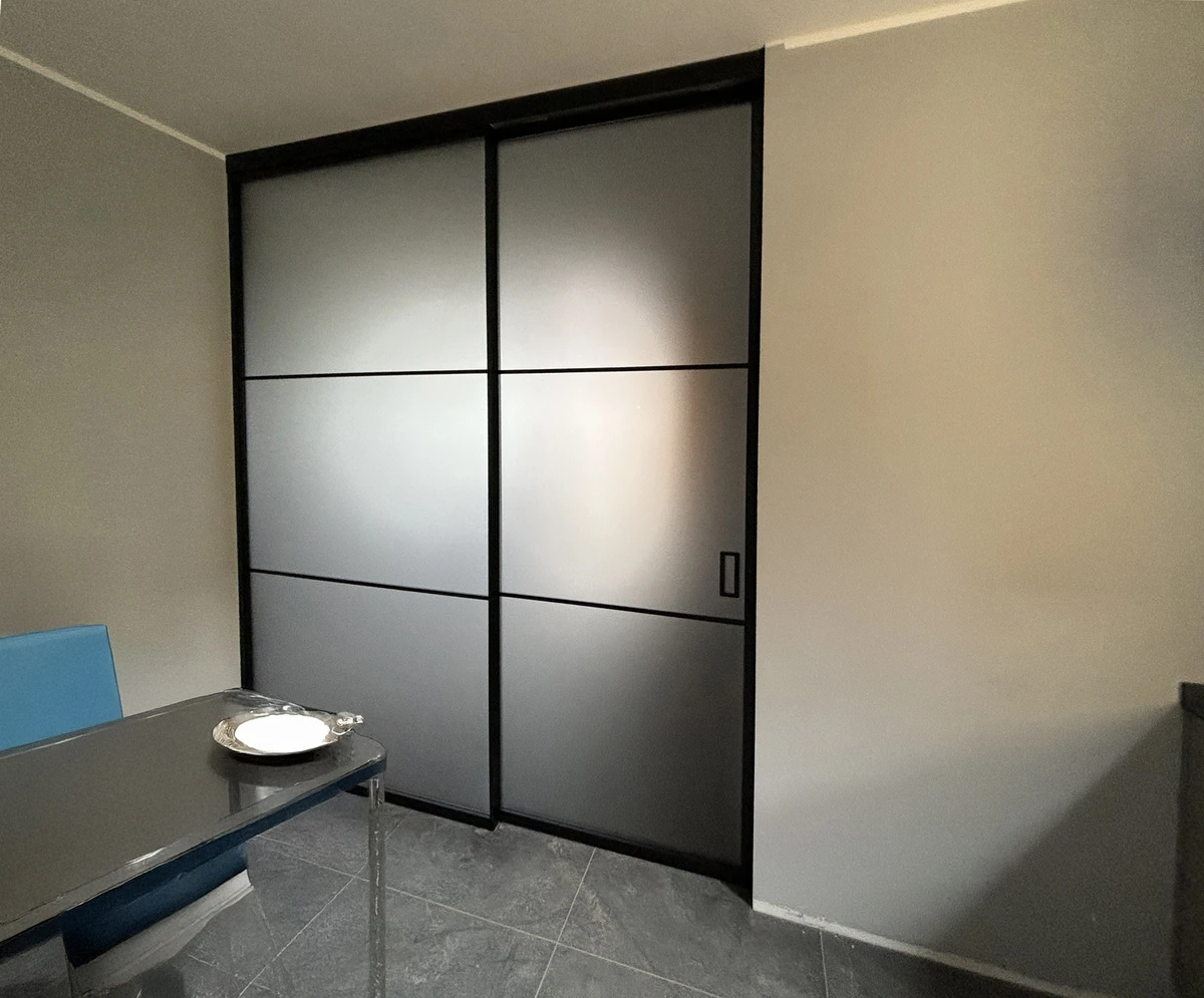 Porta interna in vetro opaco con telaio in alluminio sottile color nero adatta per sala da pranzo